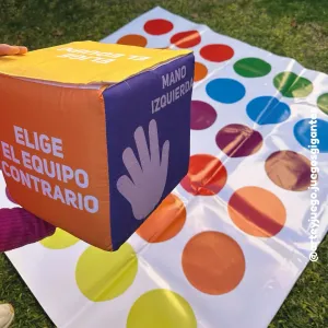 Twister Gigante 150x150: dado de tela en primer plano y lona con círculos de colores